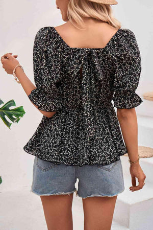 a woman wearing a black and white floral top