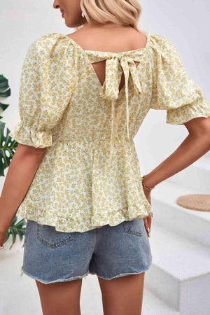 the back of a woman wearing a yellow floral top