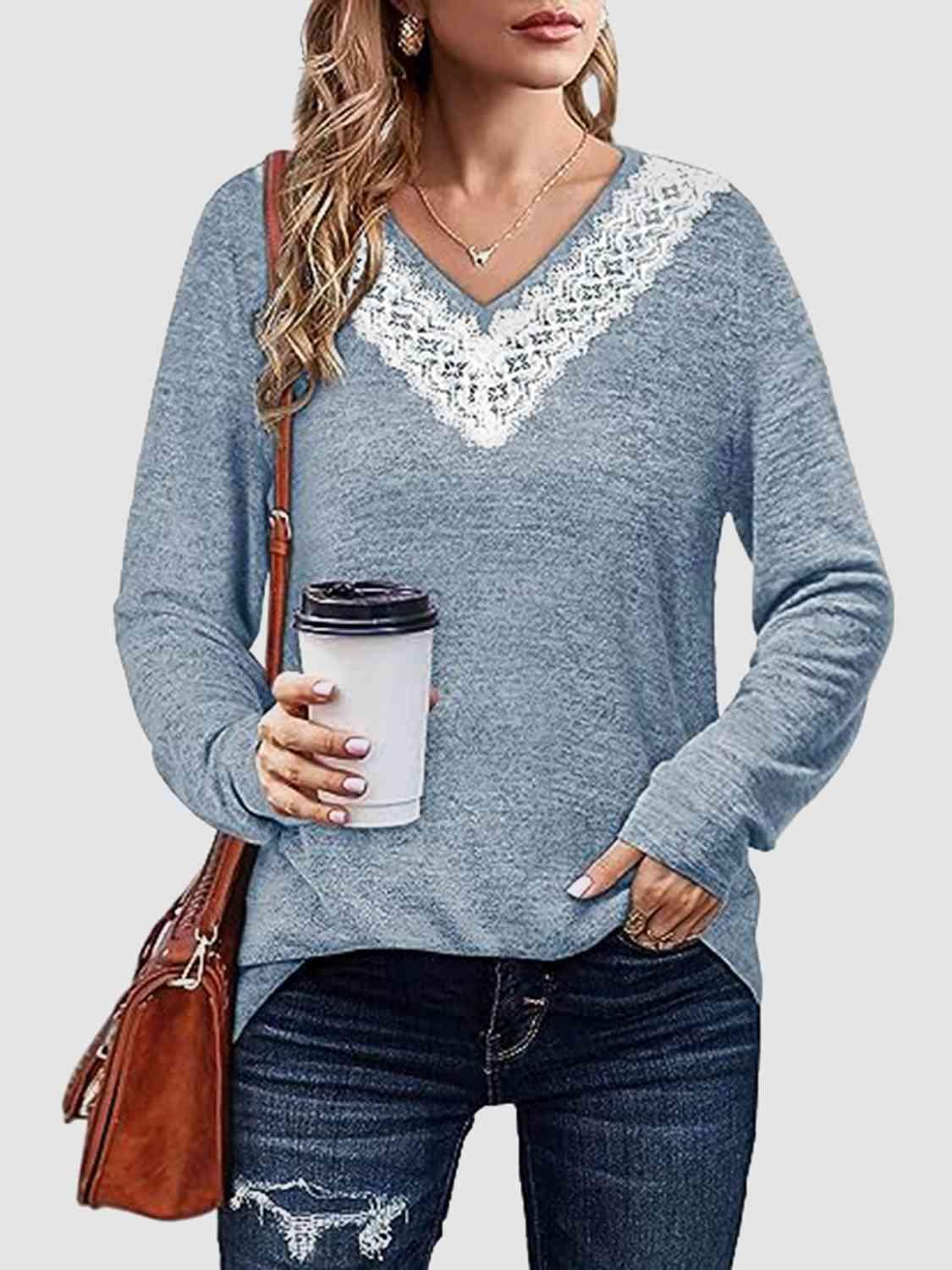 a woman holding a cup of coffee wearing a blue sweater