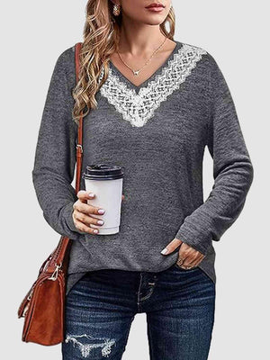 a woman holding a cup of coffee and wearing a sweater