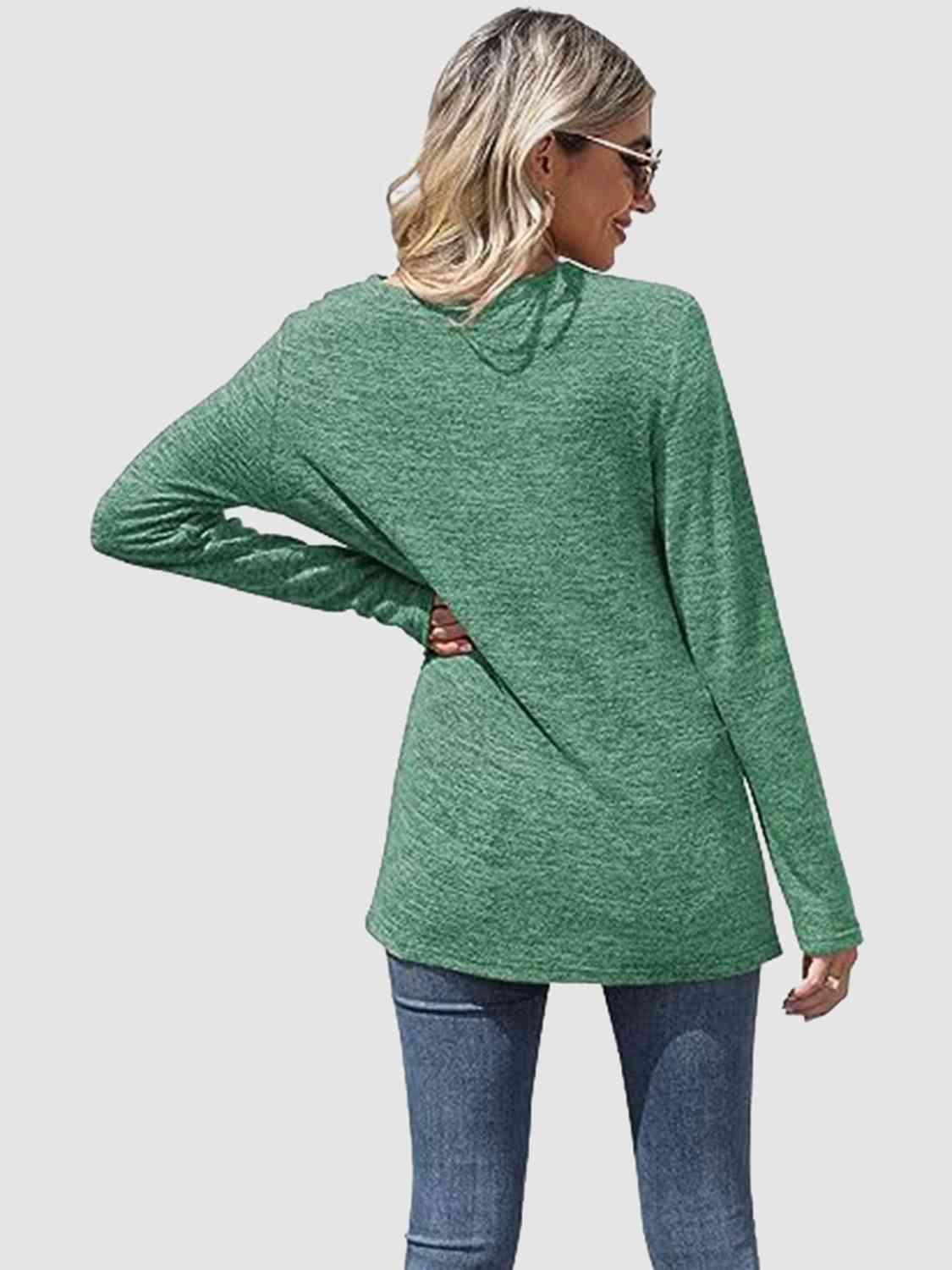 a woman wearing a green sweater and jeans