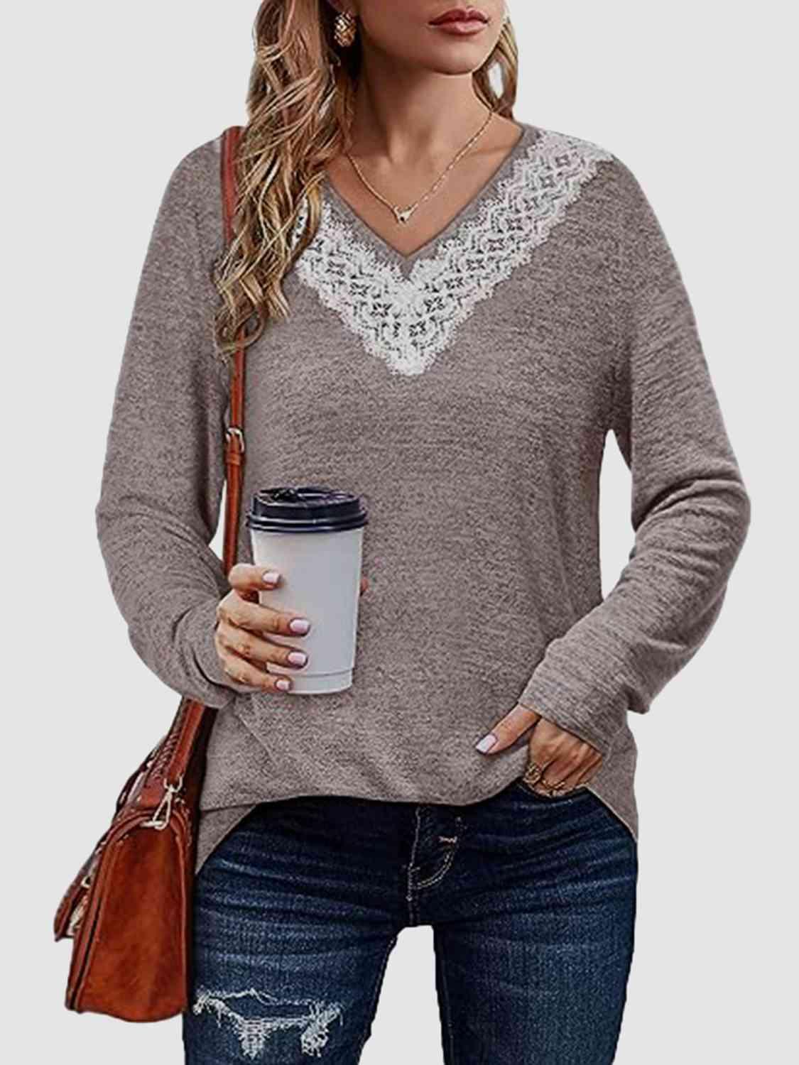 a woman holding a cup of coffee wearing a sweater