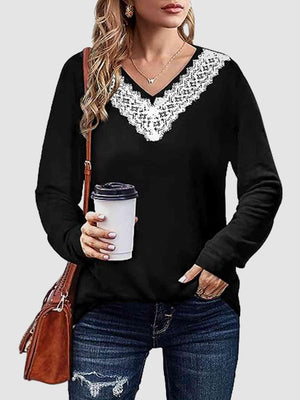 a woman holding a cup of coffee wearing a black sweater