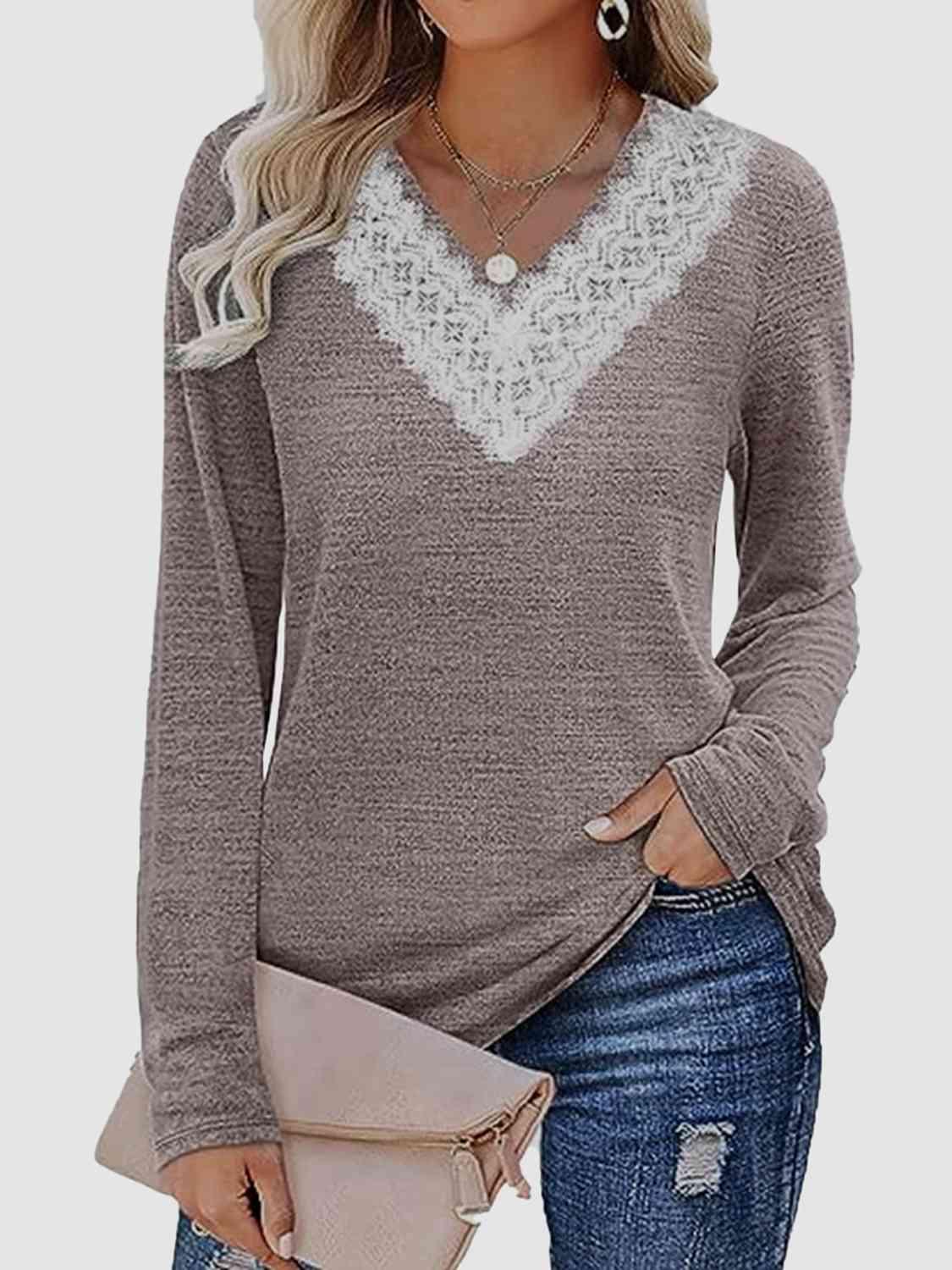 a woman wearing a grey sweater with a white lace trim