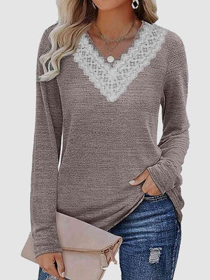 a woman wearing a grey sweater with a white lace trim