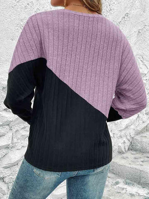 a woman wearing a purple and black sweater