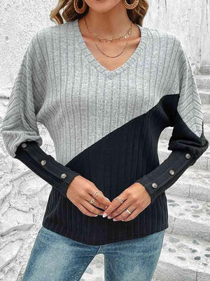 a woman wearing a gray and black sweater