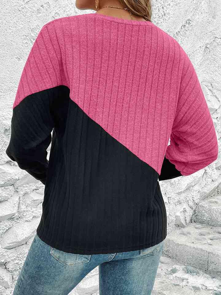 a woman wearing a pink and black sweater