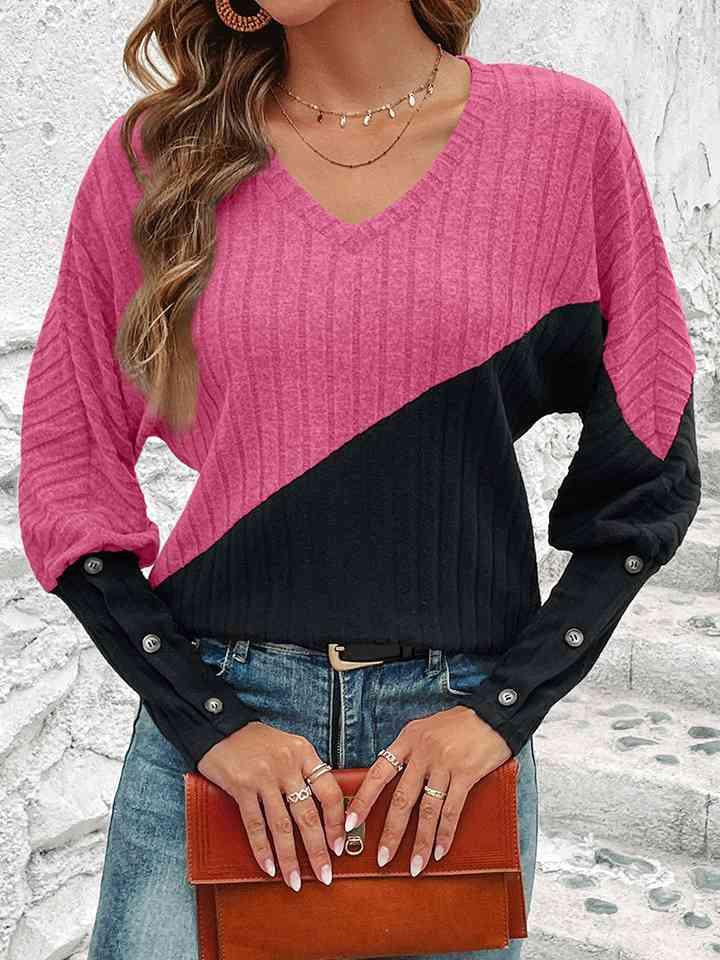 a woman wearing a pink and black sweater holding a brown purse