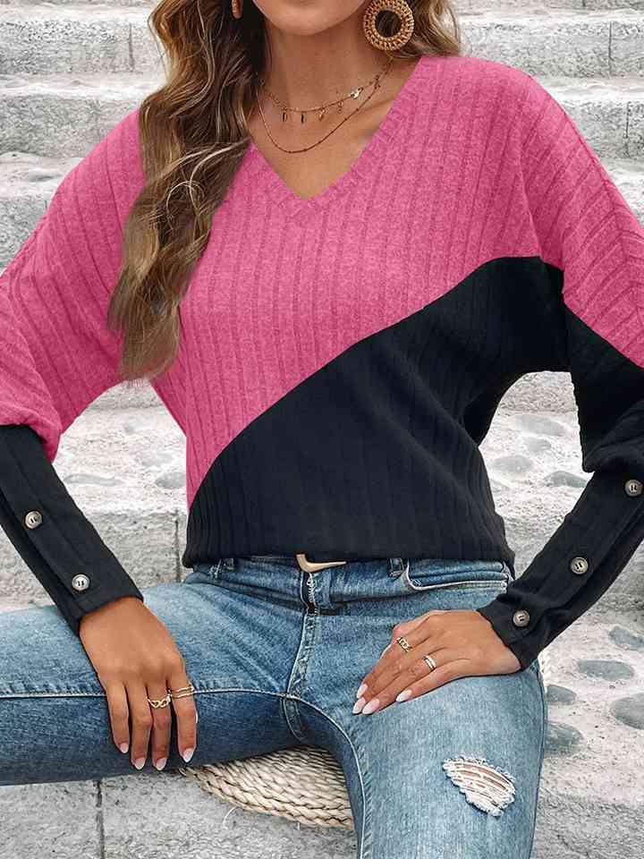 a woman wearing a pink and black sweater