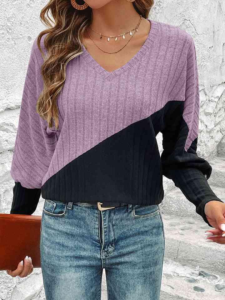 a woman wearing a purple and black sweater