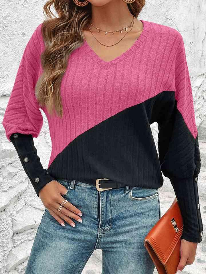 a woman wearing a pink and black sweater