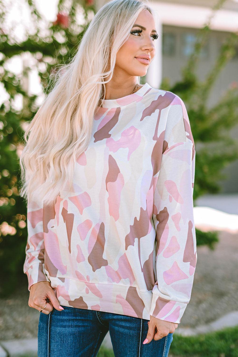 a woman wearing a pink camouflage sweater