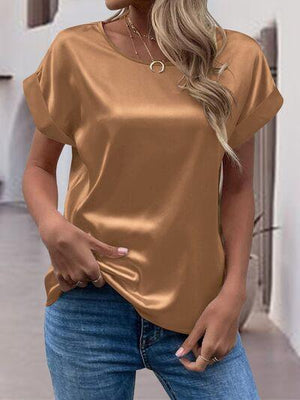 a woman wearing a gold top and jeans
