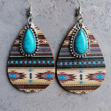 a pair of earrings with a turquoise stone in the center