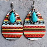 a pair of earrings with a turquoise stone in the center