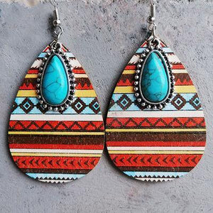 a pair of earrings with a turquoise stone in the center