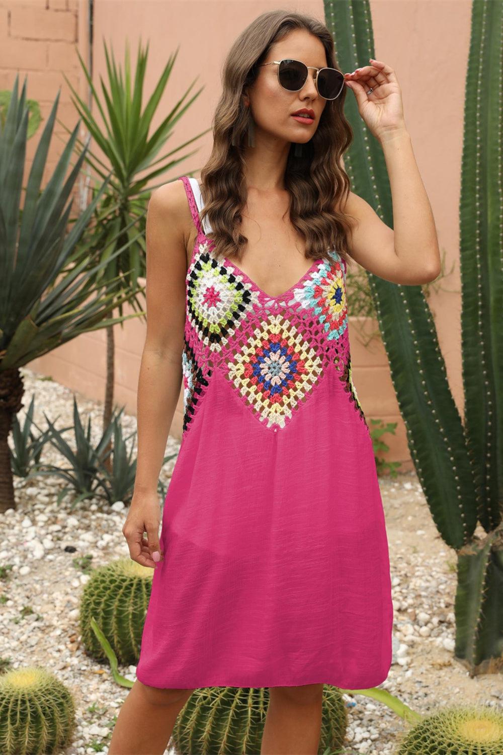 a woman in a pink dress standing next to a cactus