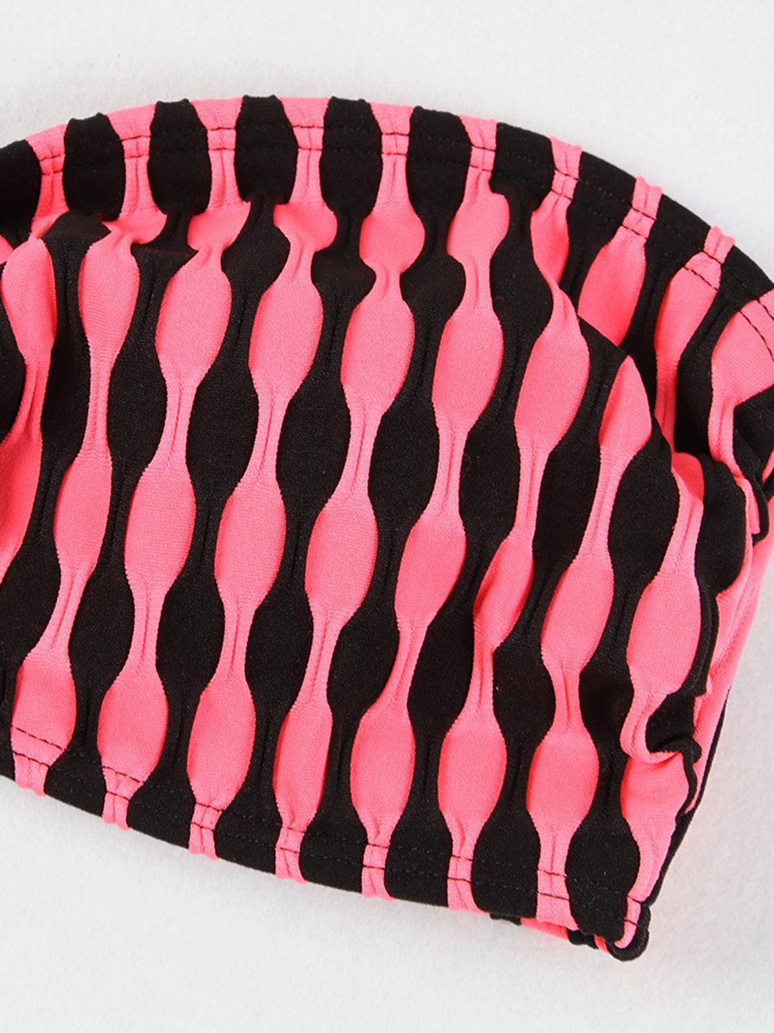 a close up of a pink and black bag on a white surface
