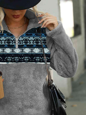 a woman wearing a gray sweater and a black hat