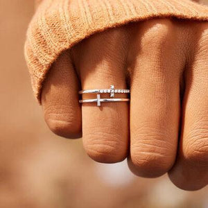 a person's hand with a cross ring on it