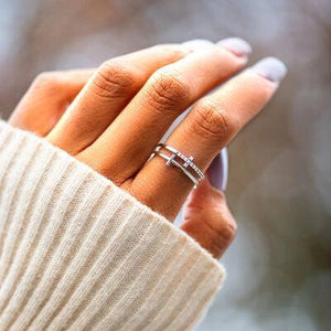 a woman's hand holding a cell phone with a diamond ring on it