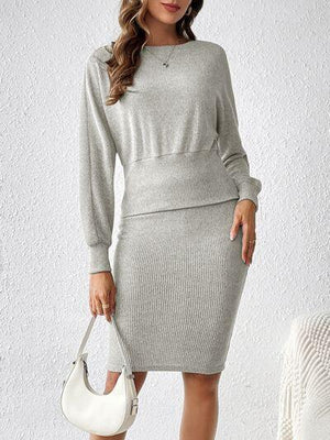 a woman wearing a grey sweater dress