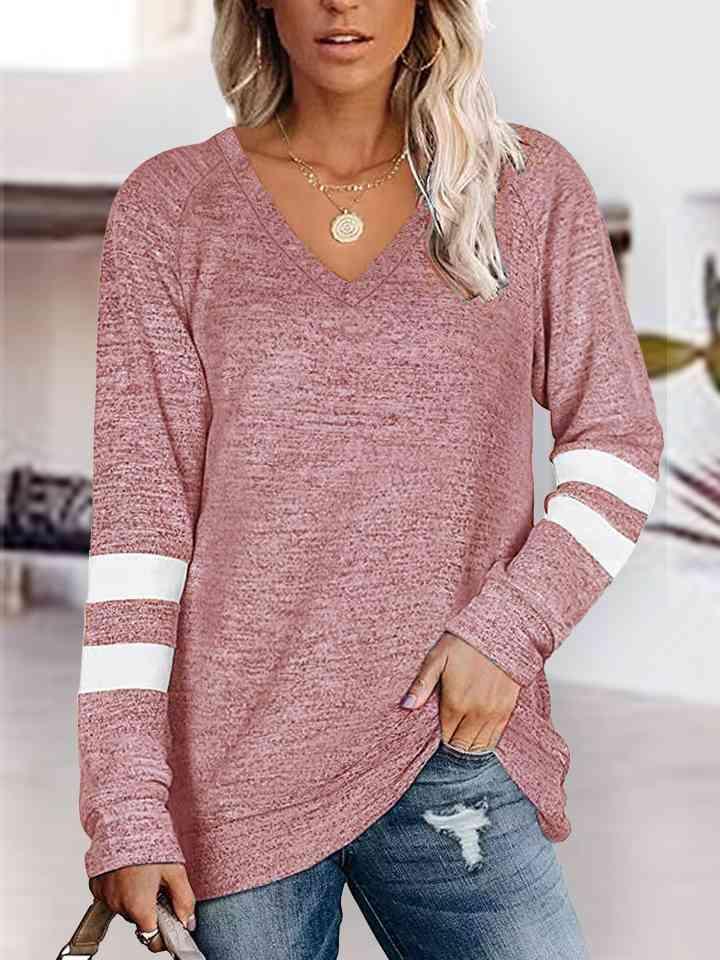 a woman wearing a pink sweater and ripped jeans