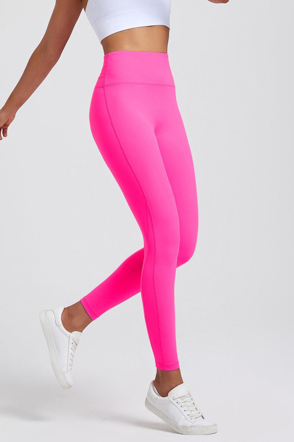 a woman in a white top and pink leggings