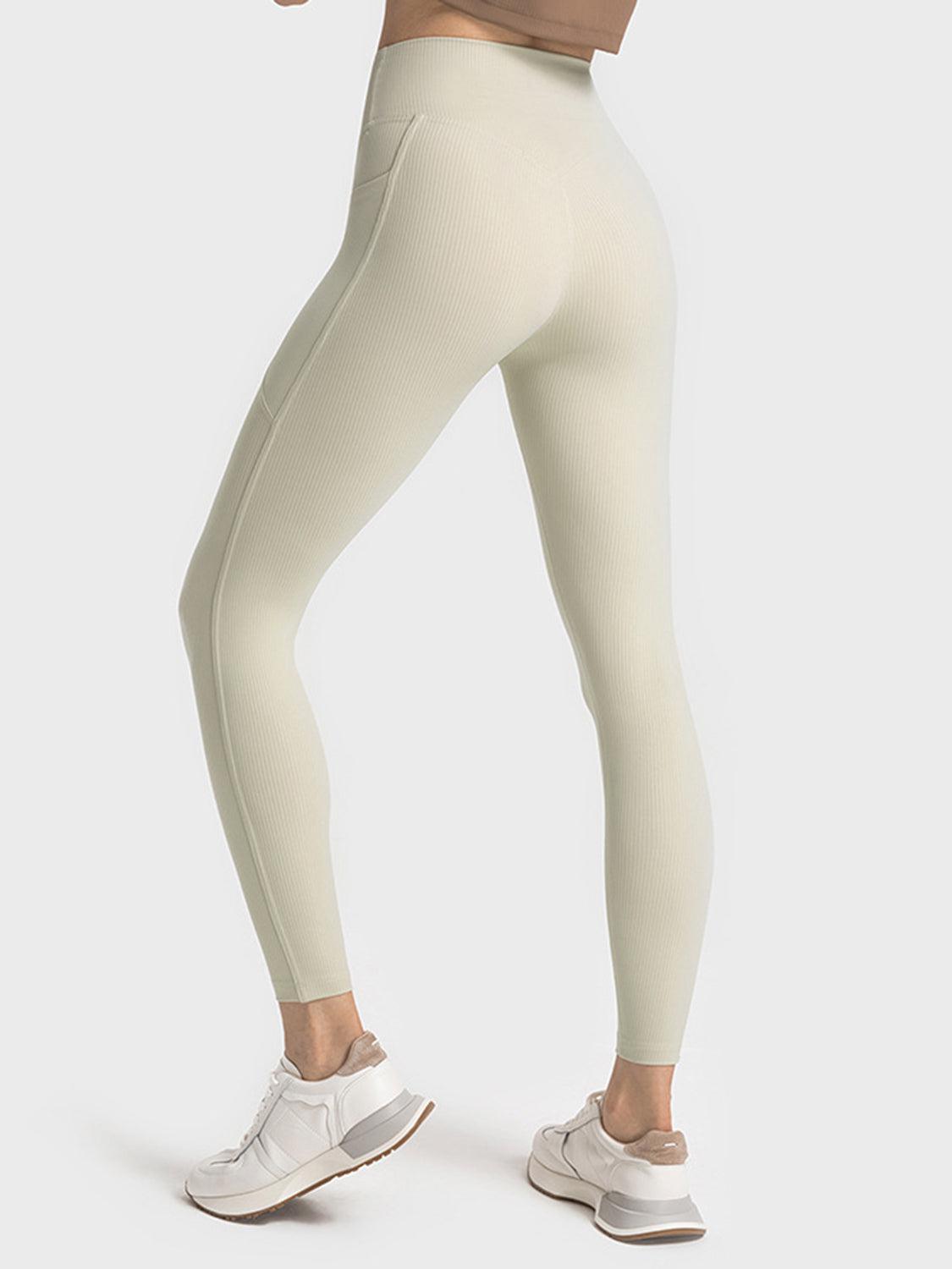a woman in a tan top and white leggings