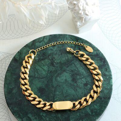 a gold chain bracelet on a green marble plate