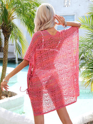 a woman standing in front of a pool wearing a pink crochet cover up