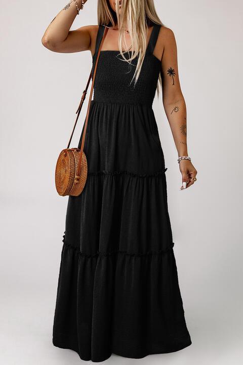 a woman wearing a black dress and a straw bag