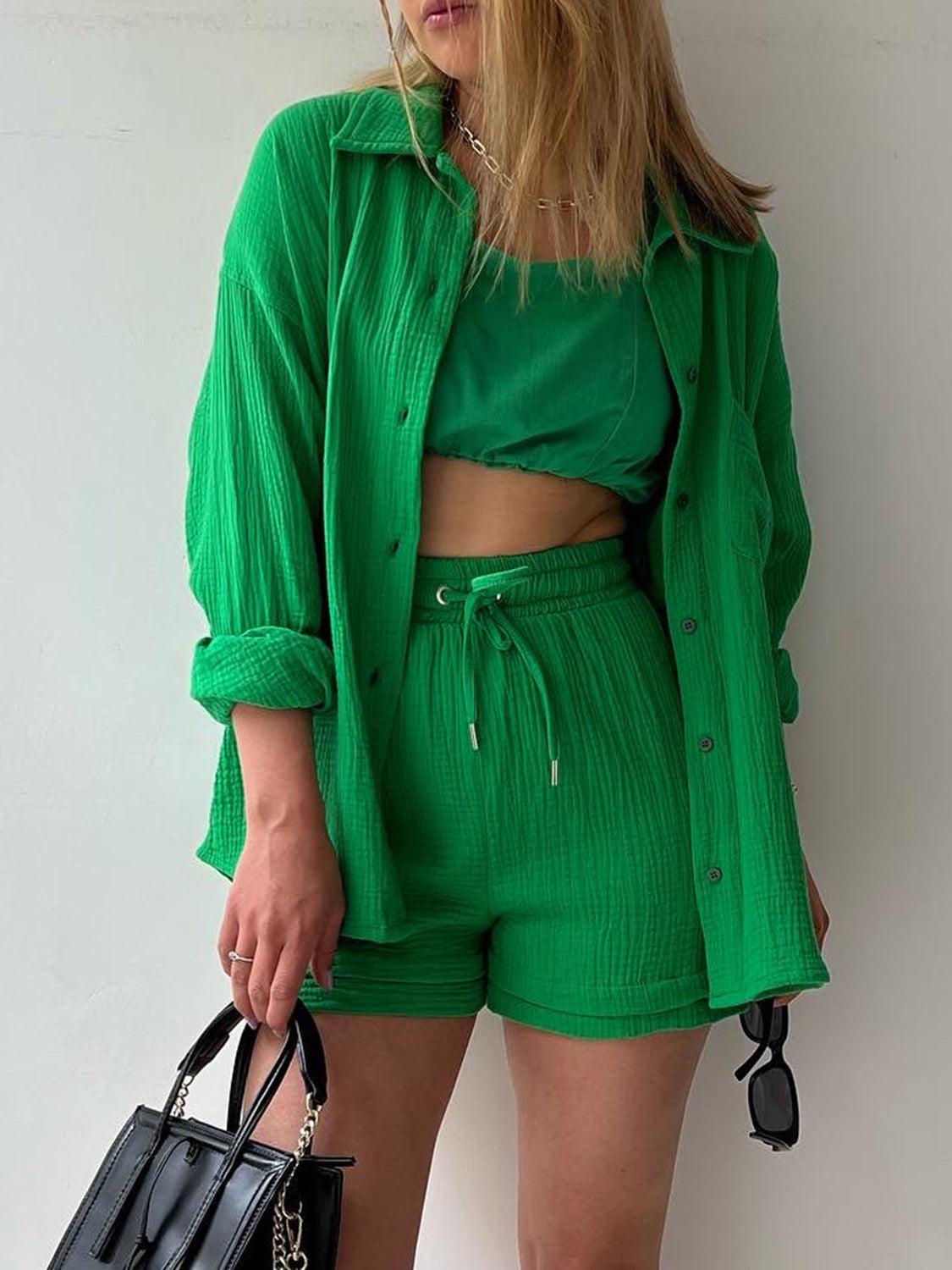 a woman in a green shirt and shorts holding a black purse