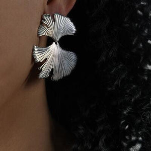 a close up of a person wearing a pair of earrings