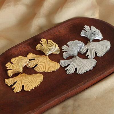 a wooden tray topped with four different types of earrings