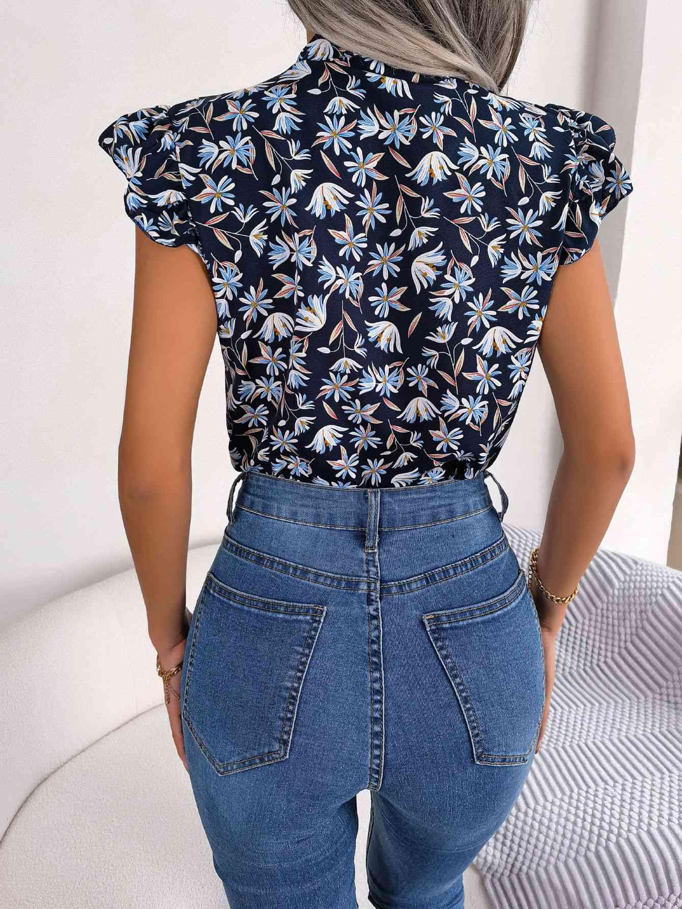 the back of a woman wearing jeans and a floral top