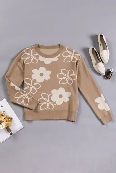 a sweater with flowers on it next to a pair of shoes