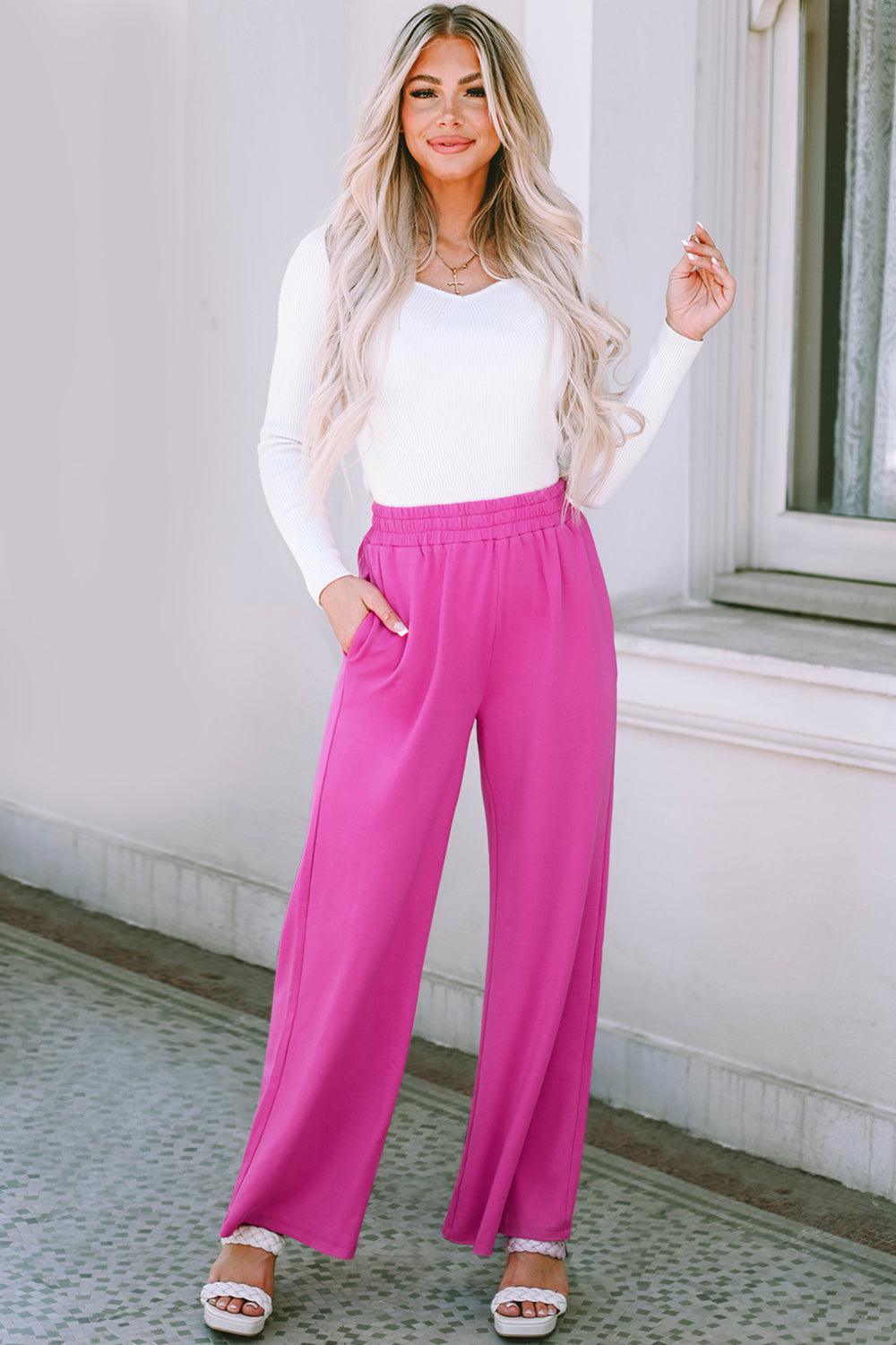 a woman in a white top and pink pants