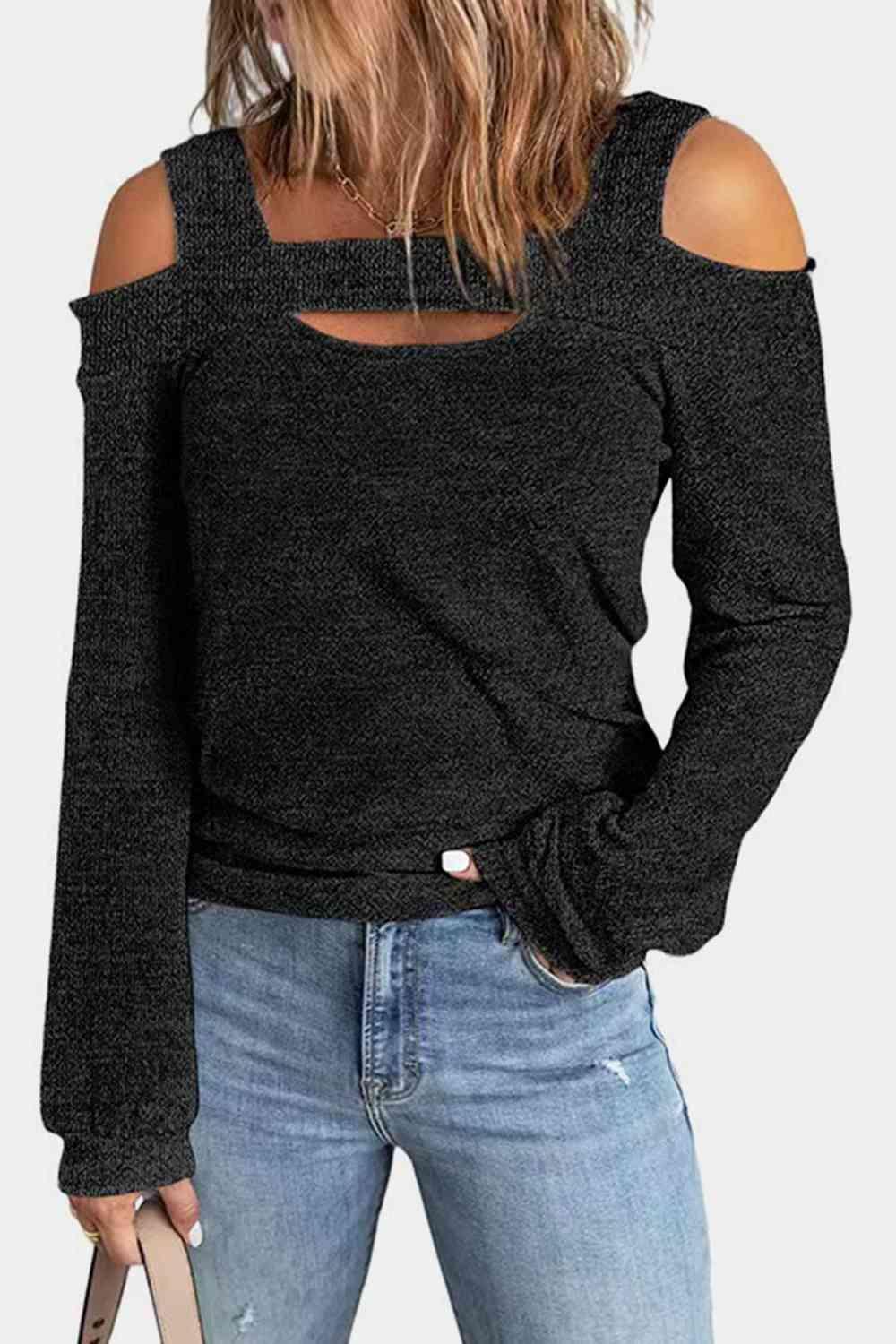 a woman wearing a black top with cut out shoulders