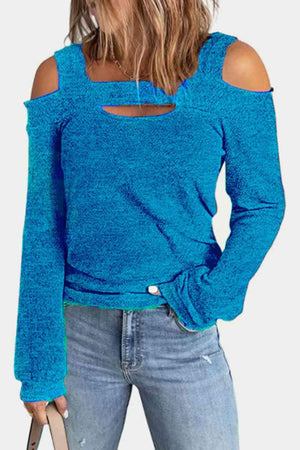 a woman wearing a blue top with cut out shoulders