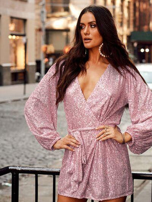 a woman in a pink dress standing on a street