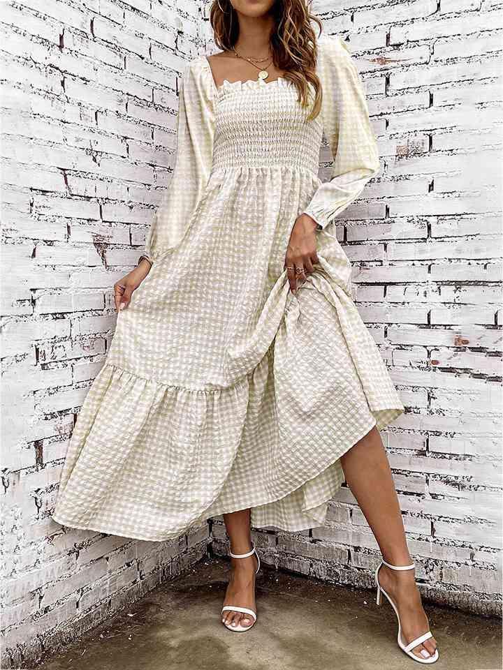 a woman in a white dress leaning against a brick wall