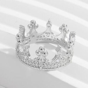 a silver crown ring on a white background