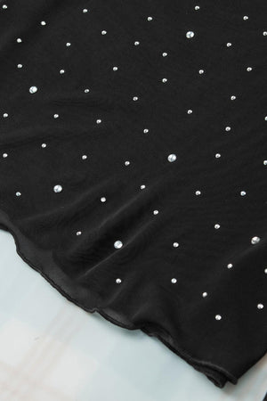 a black top with white polka dots on it