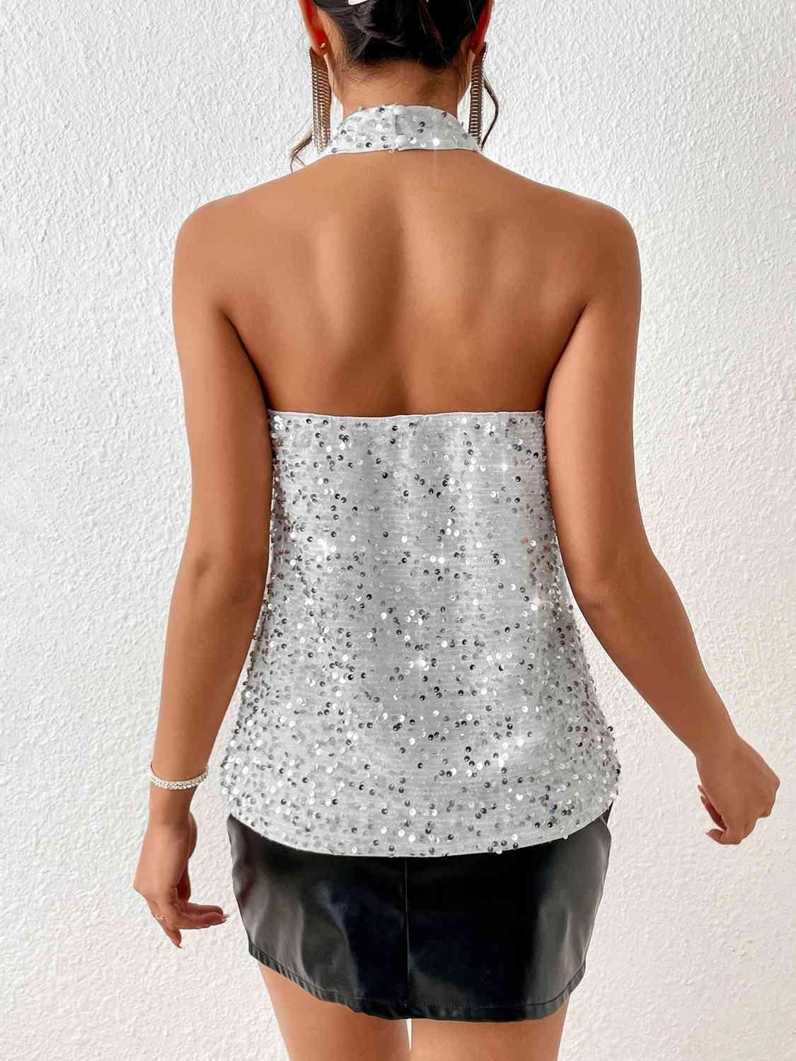 the back of a woman wearing a silver top