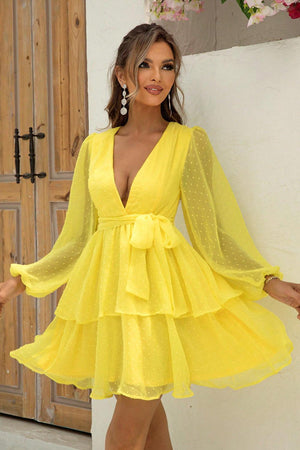 a woman in a yellow dress posing for a picture