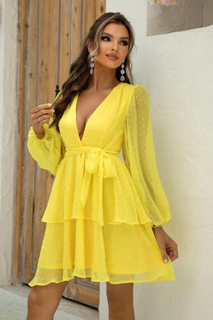 a woman in a yellow dress posing for a picture