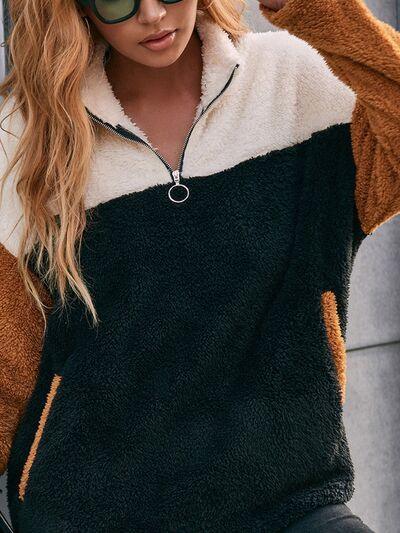 a woman wearing a black and brown color block sweater