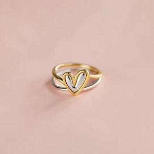 a gold ring with two hearts on it